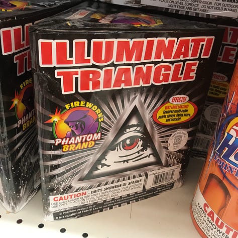DIfferent fireworks products on the shelves at Phantom; SERENITY, POINT 'N' SHOOT, ILLIMINATI TRIANGLE, BOYZ II MEN END OF THE ROAD FINALE, a shopping cart full of fireworks, GREEN WITH ENVY, NEW WORLD ORDER, FIREY FROG, and an image of someone holding a FIREY FROG and preparing to lite fuse.