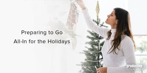 Woman hanging up a Christmas decoration. Text overlay: Preparing to Go All-In for the Holidays Woman hanging up a Christmas decoration. Text overlay: Preparing to Go All-In for the Holidays