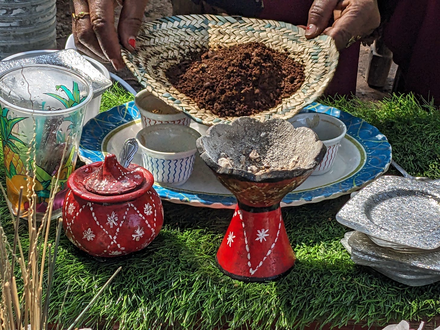 A black woman is holding ground coffee in a wicker sleeve. We don’t see her face. A black woman is holding ground coffee in a wicker sleeve. We don’t see her face.