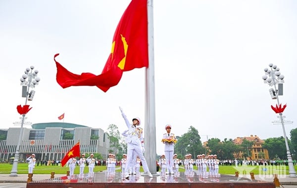 Vietnamese military honor guards in white uniforms perform a solemn flag-raising ceremony with the national red flag at Ba Dinh Square in Hanoi during Vietnam's 81st National Day.