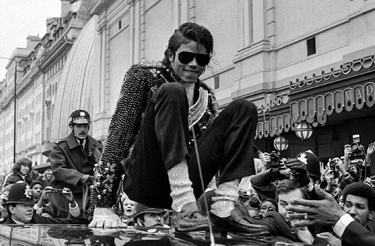 This may contain: a man on a skateboard in the middle of a parade with other people behind him