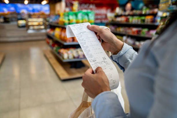 Woman shopping at a convenience store and checking her receipt Close-up on a woman shopping at a convenience store and checking her receipt while exiting price increase stock pictures, royalty-free photos & images Woman shopping at a convenience store and checking her receipt Close-up on a woman shopping at a convenience store and checking her receipt while exiting price increase stock pictures, royalty-free photos & images