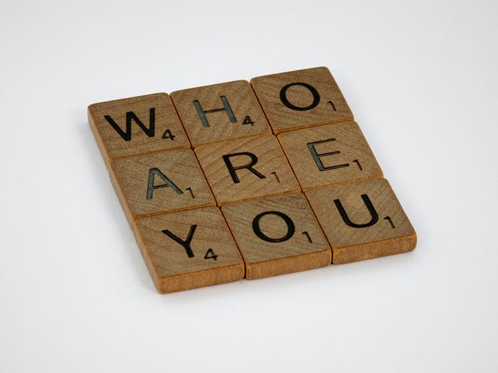 Scrabble tiles spelling out the words ‘who are you’.