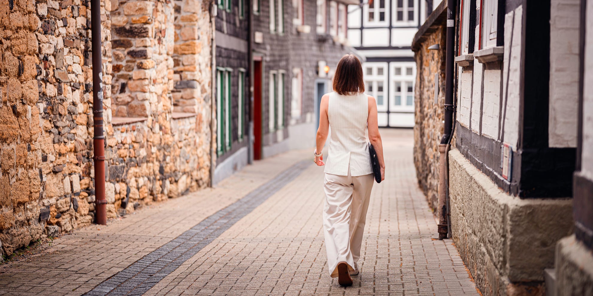 Woman with laptop walking through alleyways representing the concept of writing by feel. Woman with laptop walking through alleyways representing the concept of writing by feel.