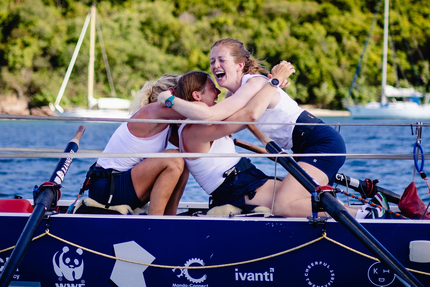 Three woman hug on a row boat after completing a 3,000-mile race Three woman hug on a row boat after completing a 3,000-mile race
