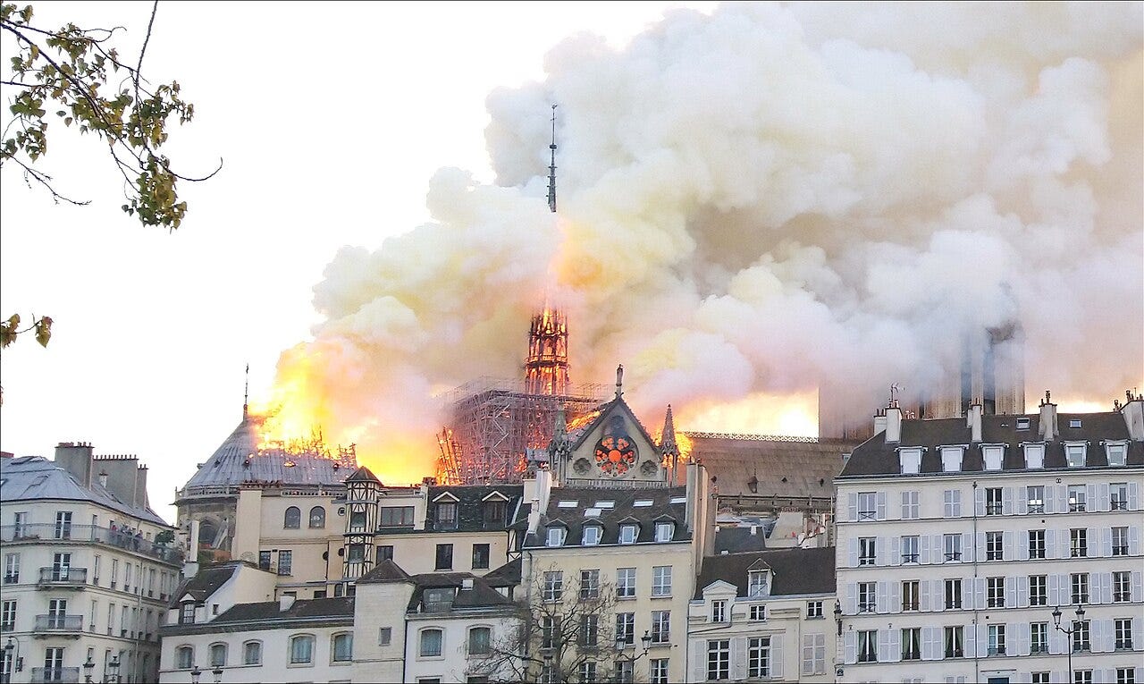 The burning roof of Notre-Dame seen over Paris rooftops