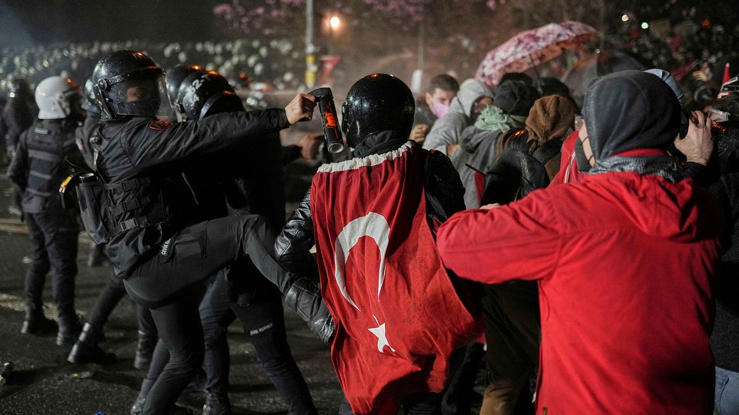 A riot police officer kicks a protester as they clash during after Istanbul's Mayor Ekrem Imamoglu was arrested and sent to prison, in Istanbul, Turkey on Sunday.