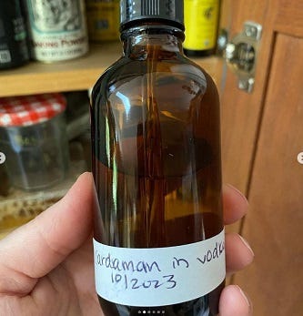 amber bottle with "cardamom in vodka" label amber bottle with "cardamom in vodka" label