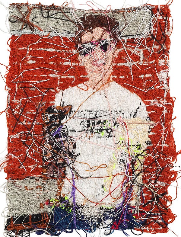 1) A white person is smiling at the viewer. They are wearing a white shirt that says 'Stop telling women to smile' In either hand, they are holding chihuahuas, one that is tan and white with a green/yellow color, and the other dog is black, white, and brown, with a purple color. Both dogs have red tags. The person is standing against a red, brick background. They are wearing pink-framed glasses. 2) The verso side of the image is seen with over and underlapping strings and threads that make up the front of the piece.