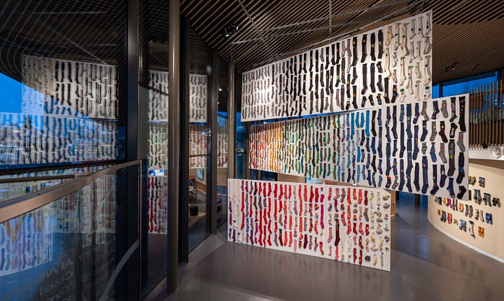 Photos of the NOW Gallery x Celia Pym exhibition Socks: The Art of Care and Repair showing a display of 488 pairs of mended socks [Credit: NOW Gallery].