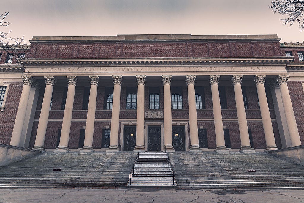 Large Neoclassical brick building with 12 Corinthian columns, sitting atop 25 or so stairs. The relief above the columns reads "THE HARRY ELKINS WIDENER MEMORIAL LIBRARY A.D. MCMXIV" Large Neoclassical brick building with 12 Corinthian columns, sitting atop 25 or so stairs. The relief above the columns reads "THE HARRY ELKINS WIDENER MEMORIAL LIBRARY A.D. MCMXIV"