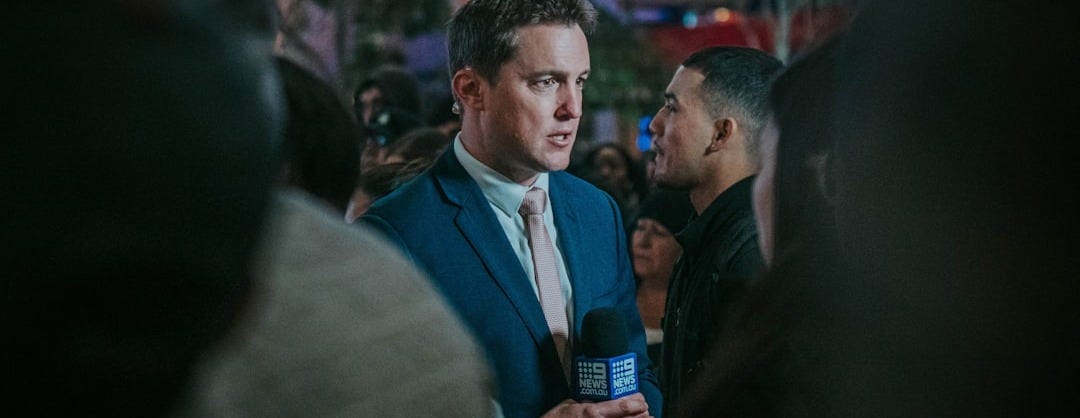 man in black suit standing in front of man in black suit man in black suit standing in front of man in black suit