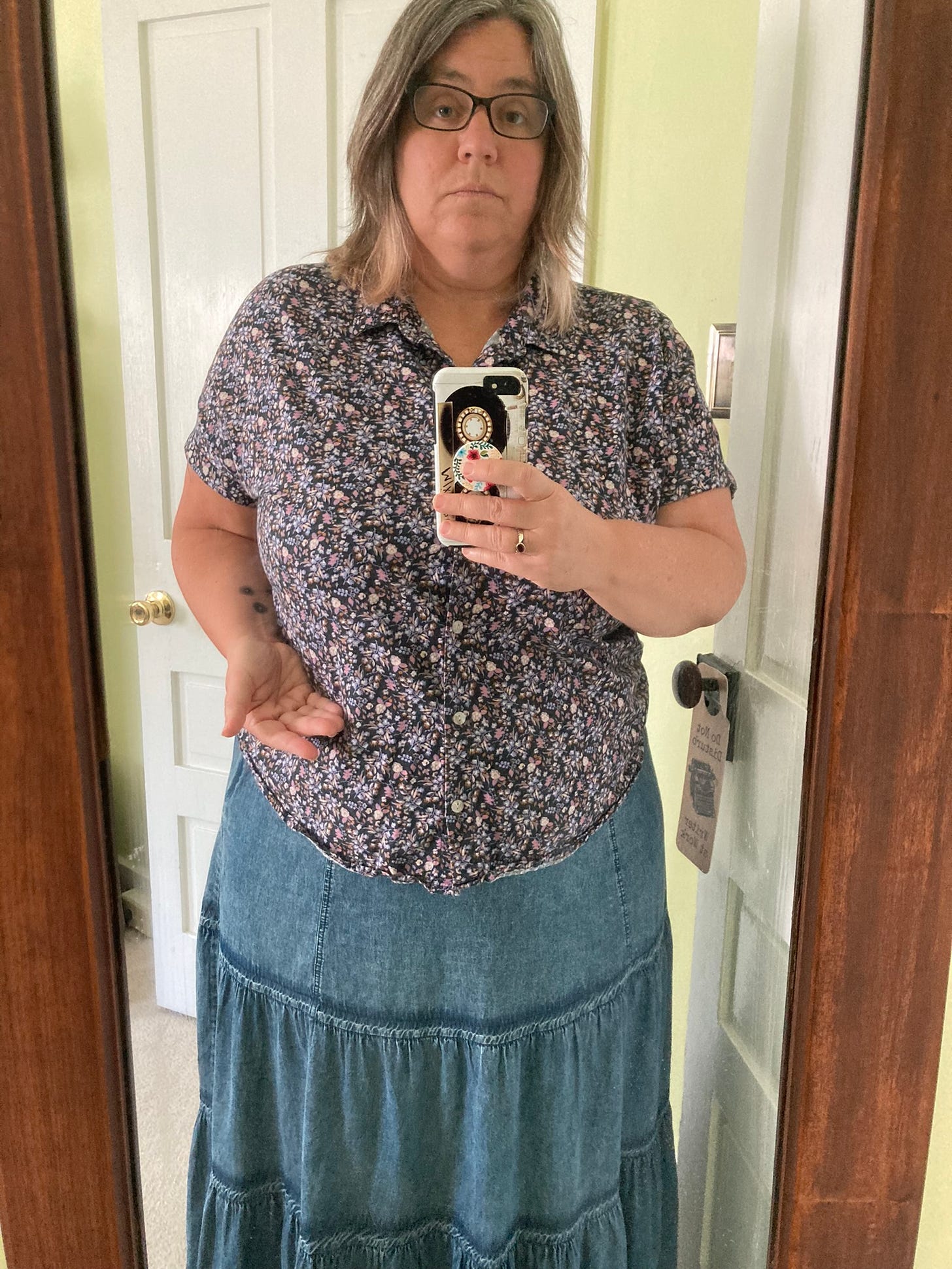 Robyn looking uncertain in a flower-patterned, collared shirt