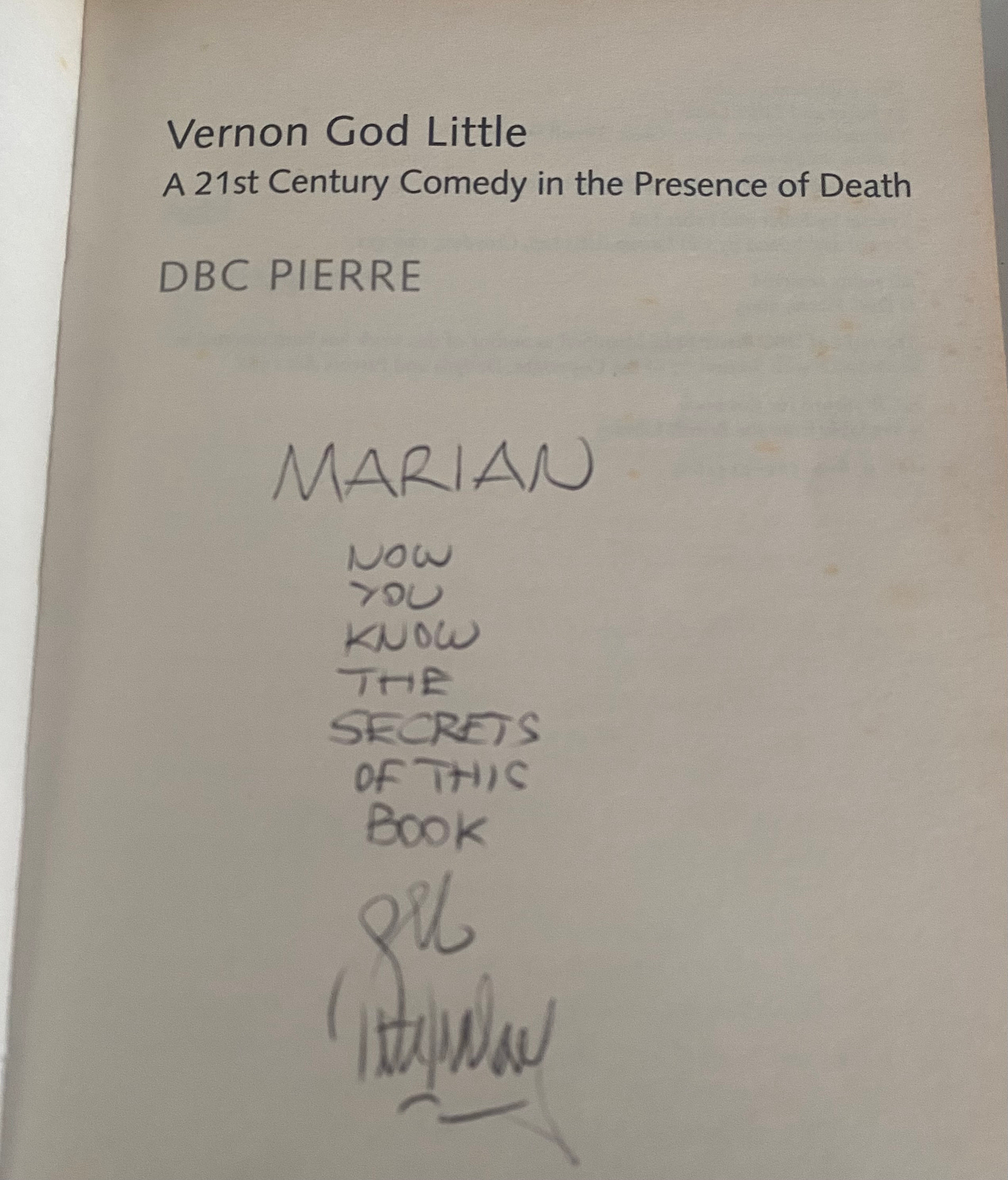 The title page of Vernon God Little by DBC Pierre with an inscription: Marian, now you know the secrets of this book. The author's signature is illegible. 