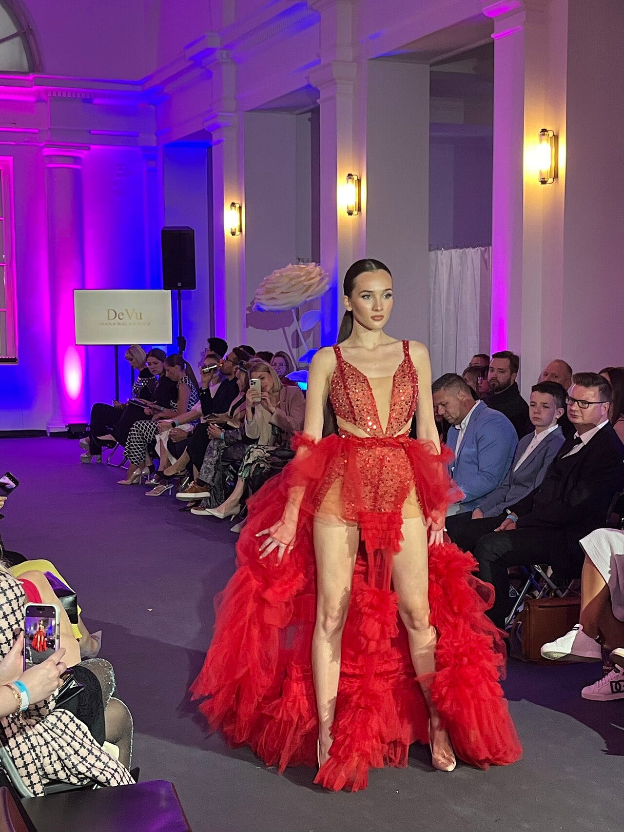 Photo: Rafał Siciński / Wikimedia Commons (CC BY 4.0) Model on the runway during the Sosnowiecki Fashion Bridge fashion event at Bank Sztuki in Sosnowiec, Poland. In the background is a screen for DeVu/Diana Walkiewicz, one of the designers presented during the show.
