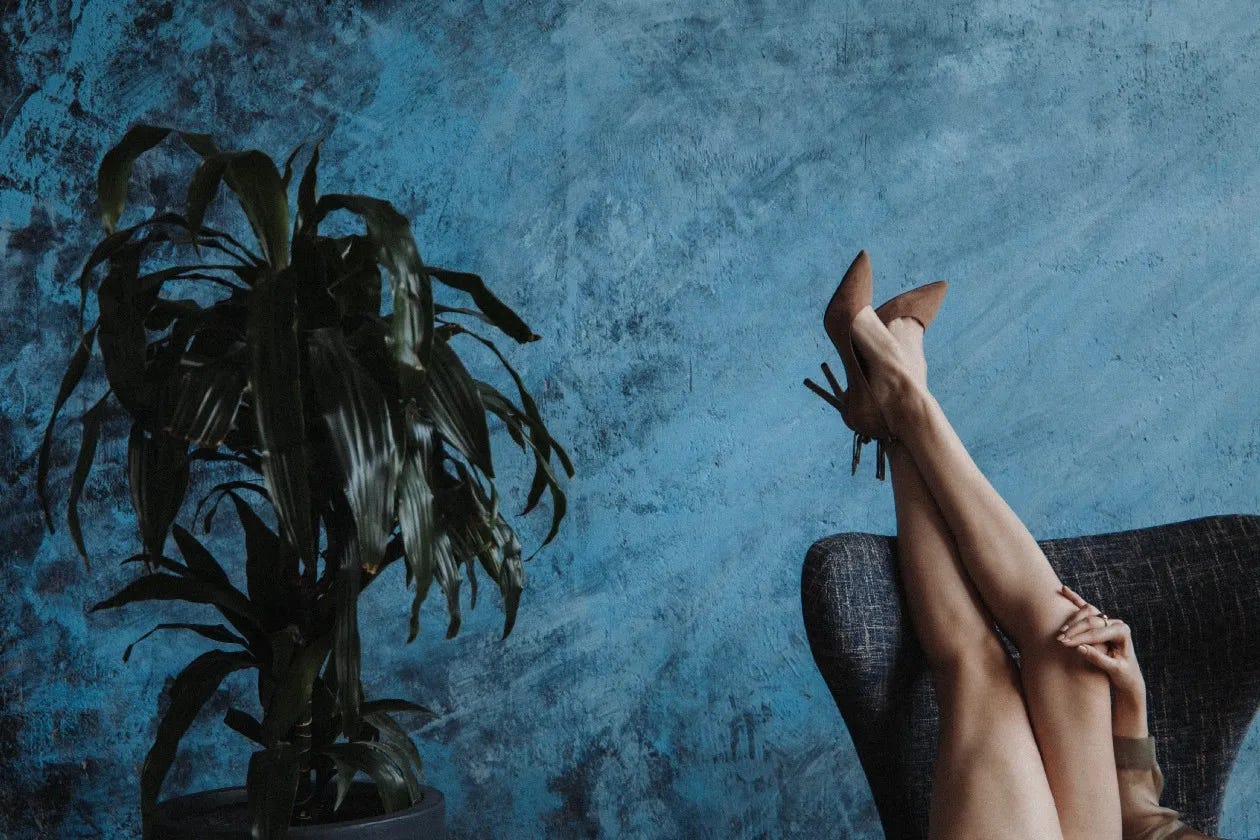 The long beautiful legs of a woman in high heels with her feet upside down in the air The long beautiful legs of a woman in high heels with her feet upside down in the air