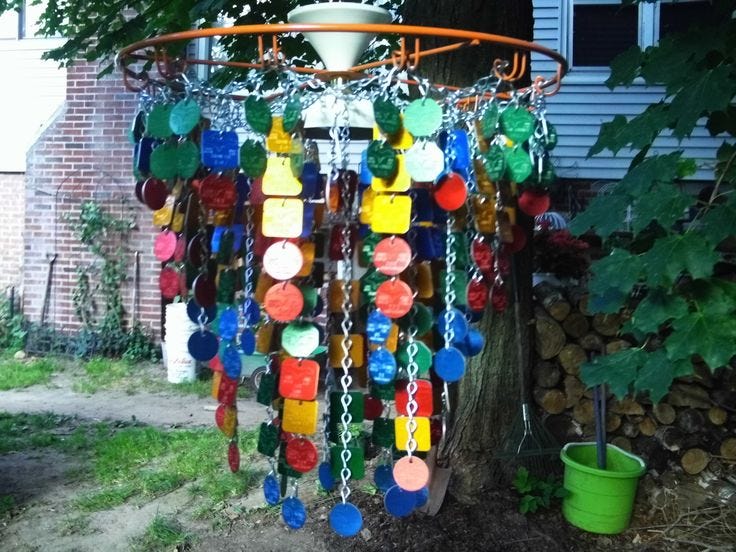 Colorful, painted pet tags attached to chains hanging in a garden