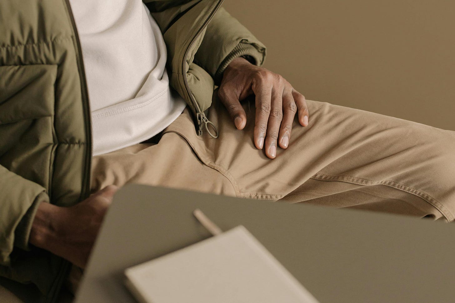 Notebook on Desk Near Man Wearing Green Puffer Jacket Notebook on Desk Near Man Wearing Green Puffer Jacket