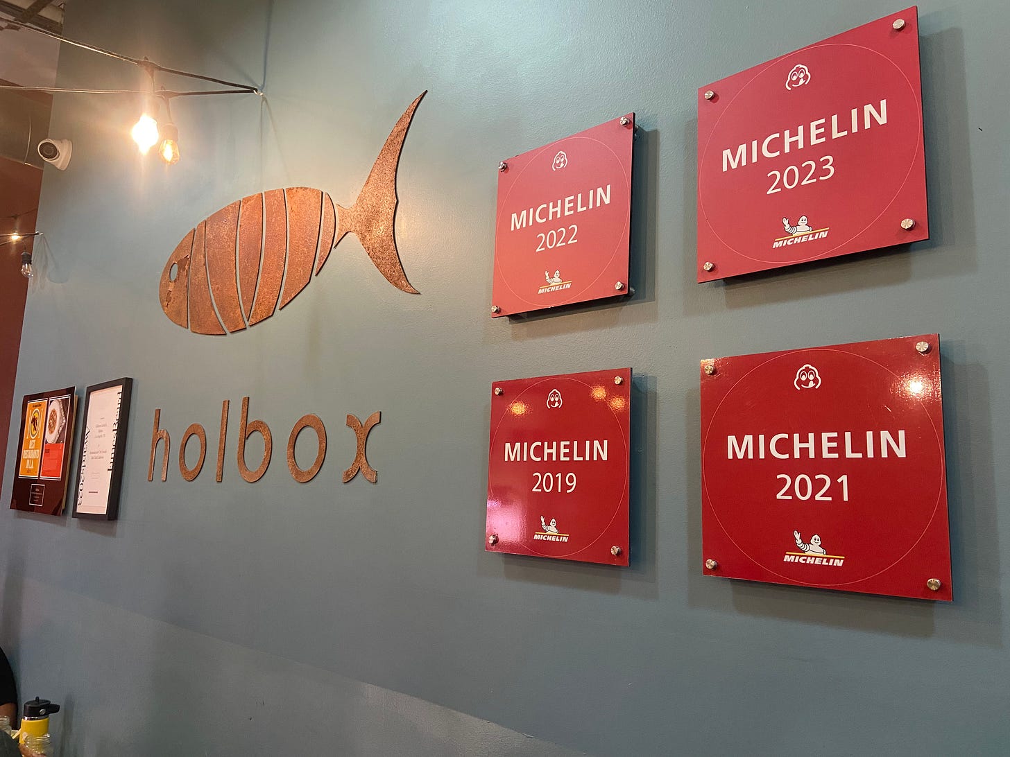 A photos of the holbox sign and four of their five Michelin stars