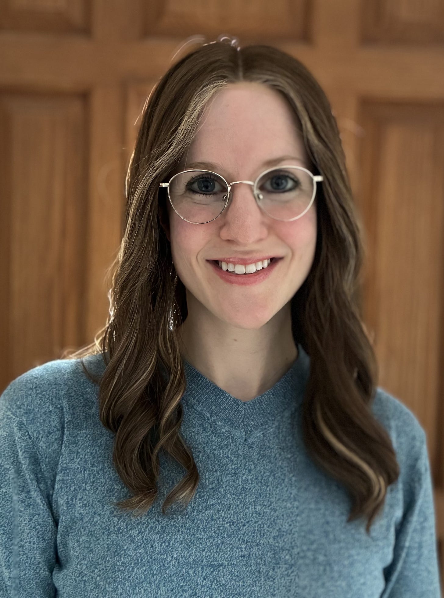 A photo of Rebecca Gluck, PA-C, wearing glasses and a blue sweater.