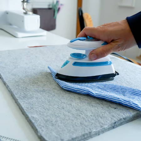 ironing the tip flat with a mini iron on a wool pressing mat ironing the tip flat with a mini iron on a wool pressing mat