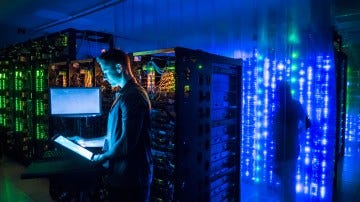 Man using a tablet in a server room.