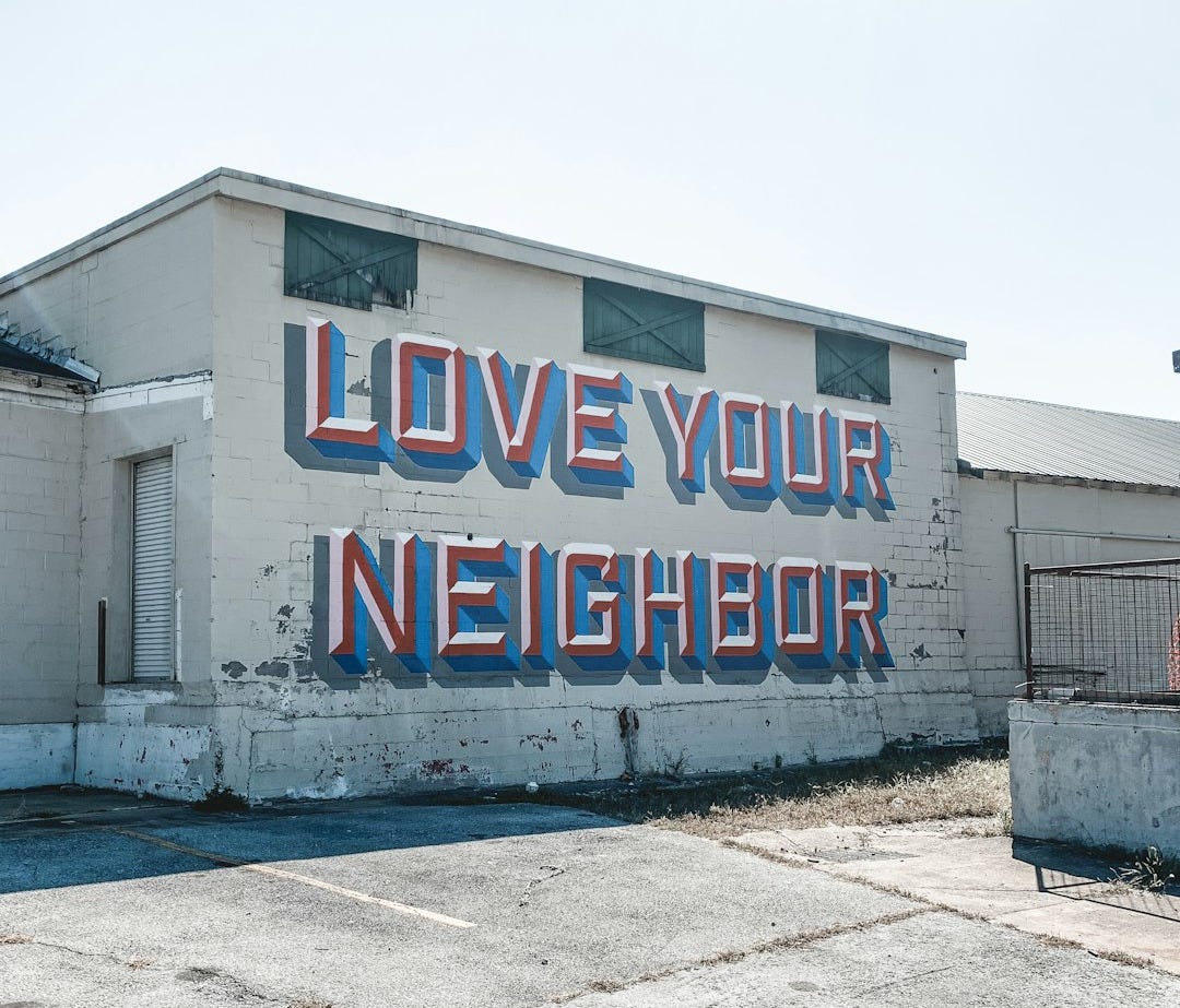 a large sign on the side of a building that says love your neighbor a large sign on the side of a building that says love your neighbor