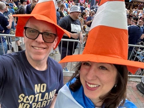 A marvelous author looks highly professional in a bright orange and white traffic cone hat. 