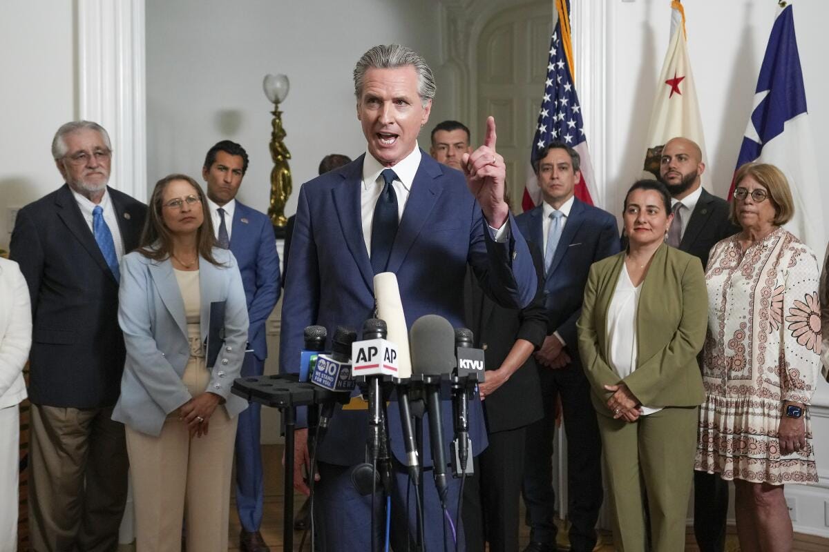 Gov. Gavin Newsom stands in front of several people. Gov. Gavin Newsom stands in front of several people.