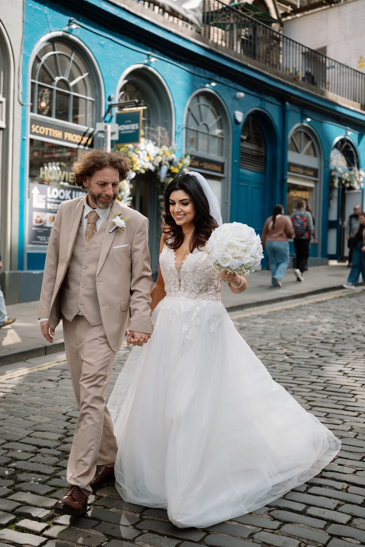 Adam Juniper and Ariane Sherine Juniper on their wedding day walking down the street