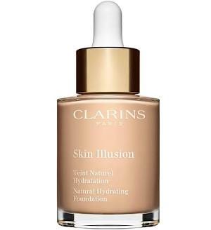 A clear, rounded glass bottle of Clarins 'Skin Illusion' foundation with a polished, reflective gold cap and an internal dropper. The foundation inside is a light, natural beige, promising a luminous, hydrating 'second skin' result. A clear, rounded glass bottle of Clarins 'Skin Illusion' foundation with a polished, reflective gold cap and an internal dropper. The foundation inside is a light, natural beige, promising a luminous, hydrating 'second skin' result.