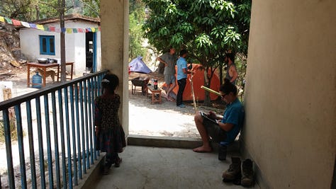 Pictures of life volunteering in disaster relief in Nepal. Tents in a courtyard, people sitting around reading books and playing games, standing on top of a damaged building, and buckets they used for washing.