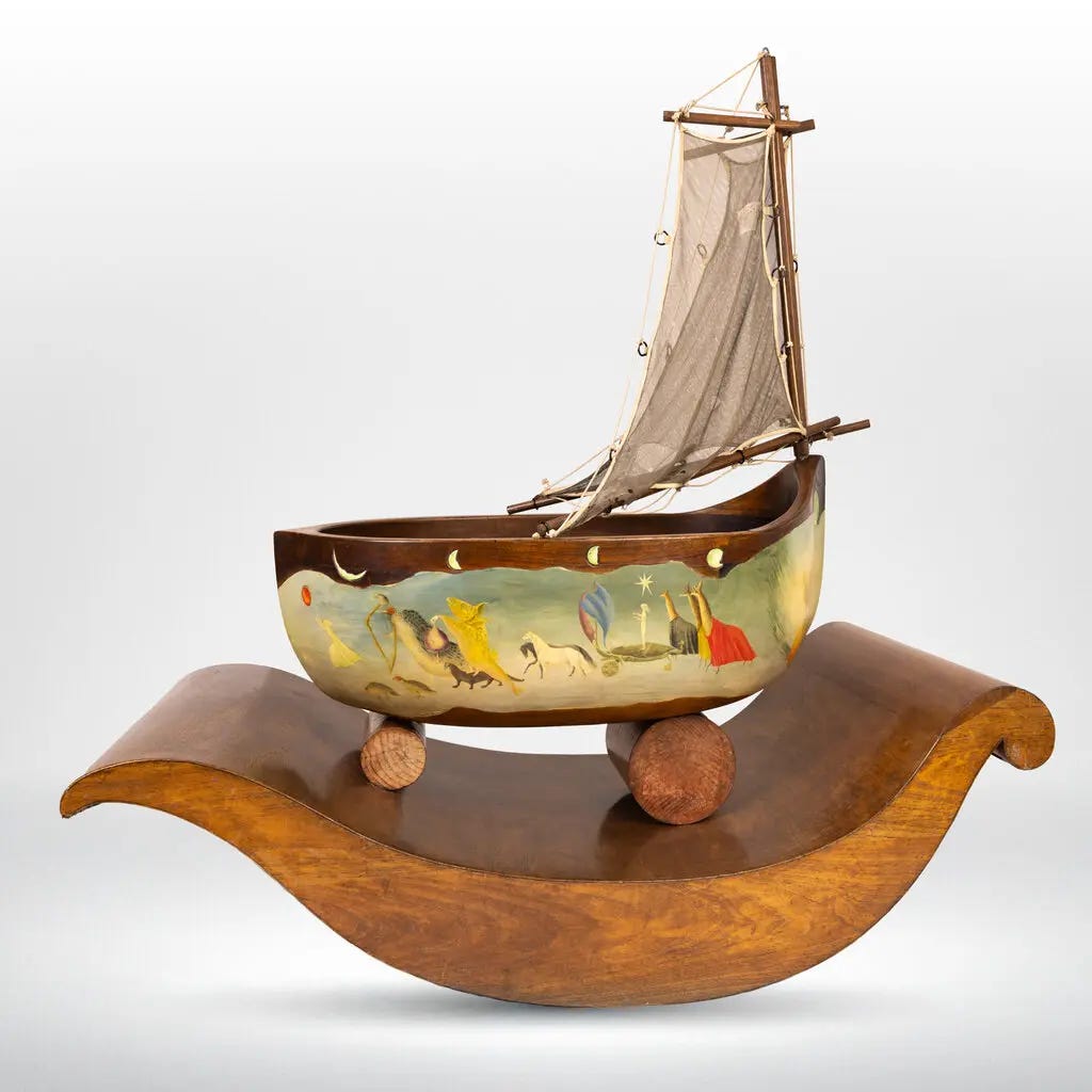 A wooden cradle, shaped like a sailboat, and with a sail attached, is painted with a colorful scene on its side depicting a girl carrying a red balloon and leading a parade of animals, including horses and llamas.