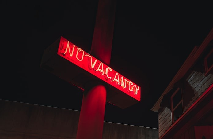 a red neon sign is lit up in the dark a red neon sign is lit up in the dark