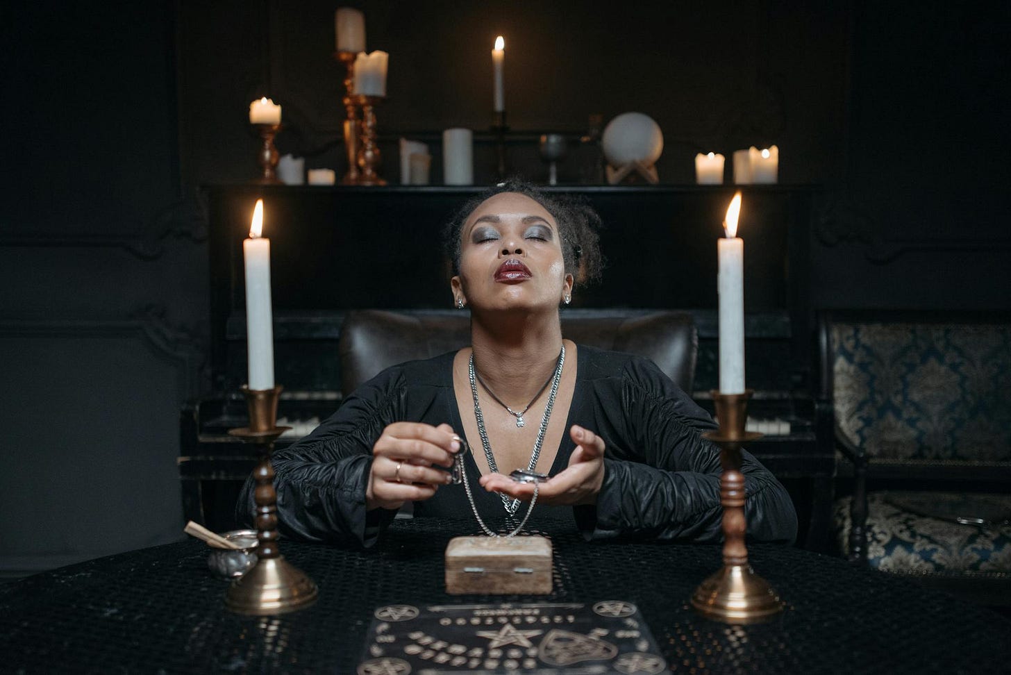 Woman in Black Clothes Sitting at the Table with Candles Woman in Black Clothes Sitting at the Table with Candles