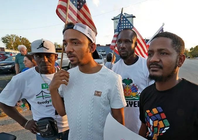Left: A Peace Rally was held at the Springfield Democratic headquarters on Park Road. Right: A group of Haitian immigrants, Petuel Jeanjacques, Ricardo Omarra, Tamis Giracia, and Joseph Nelius, participate in the Peace Rally. Photo: Bill Lackey/Springfield News-Sun, Sept. 18, 2024.