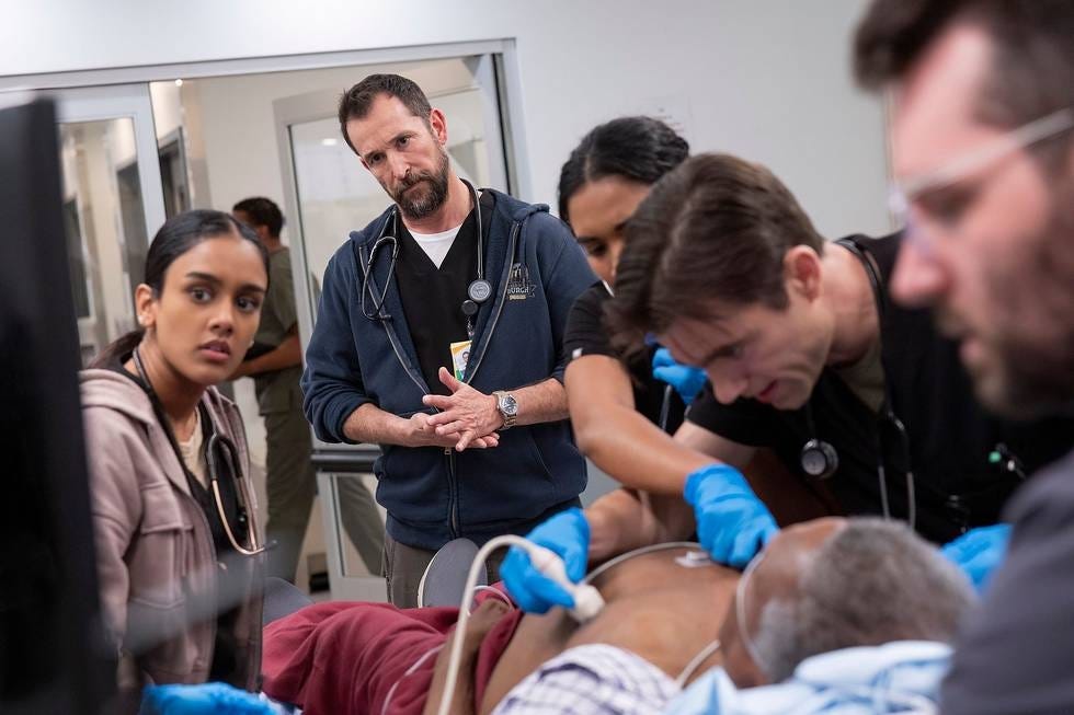 A still from the Max series The Pitt. The doctors gather around a patient, watching a monitor. A still from the Max series The Pitt. The doctors gather around a patient, watching a monitor.