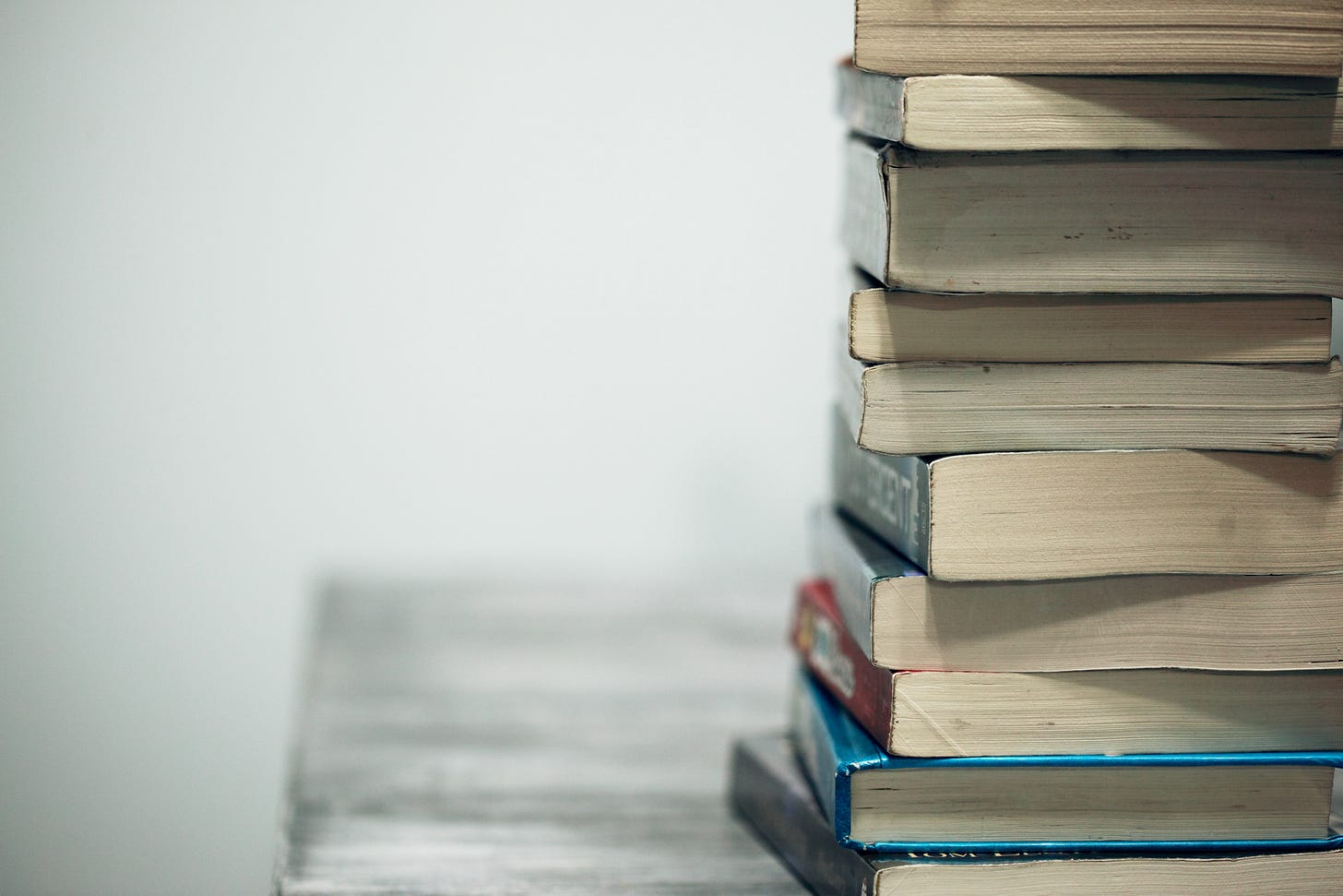 Photo of a stack of books on a table.