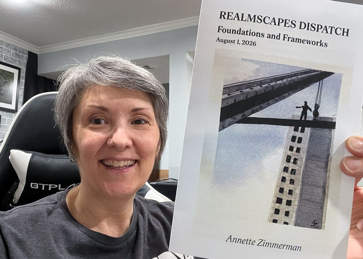 A smiling woman sits in her studio and holds up the August 2026 Realmscapes Dispatch, titled “Foundations and Frameworks.” The cover shows a construction worker standing on a steel beam above an unfinished skyscraper. A smiling woman sits in her studio and holds up the August 2026 Realmscapes Dispatch, titled “Foundations and Frameworks.” The cover shows a construction worker standing on a steel beam above an unfinished skyscraper.
