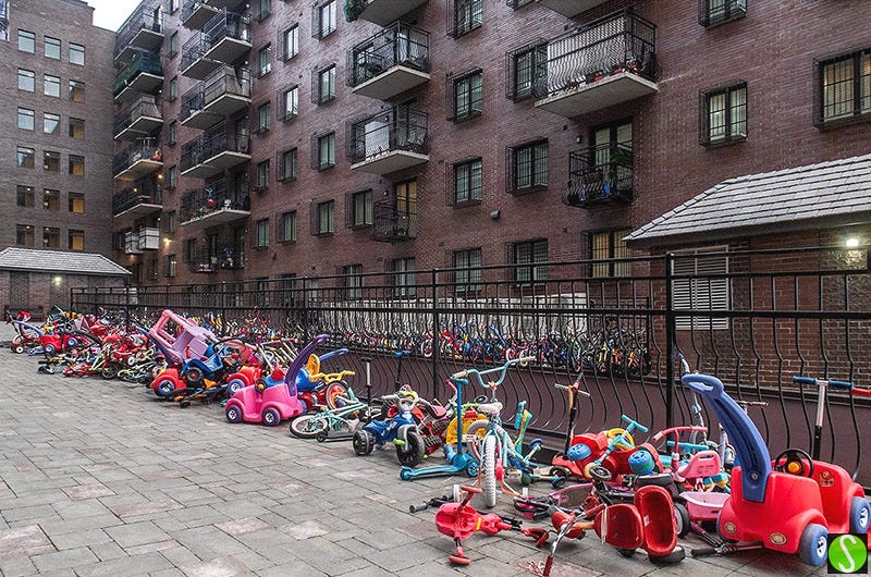 photo of piles of kids wheeled toys in Hasid housing, Brooklyn 2018. ©Steve Butcher