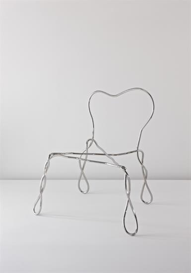 This may contain: a metal chair sitting on top of a white floor next to a wall in the shape of a heart