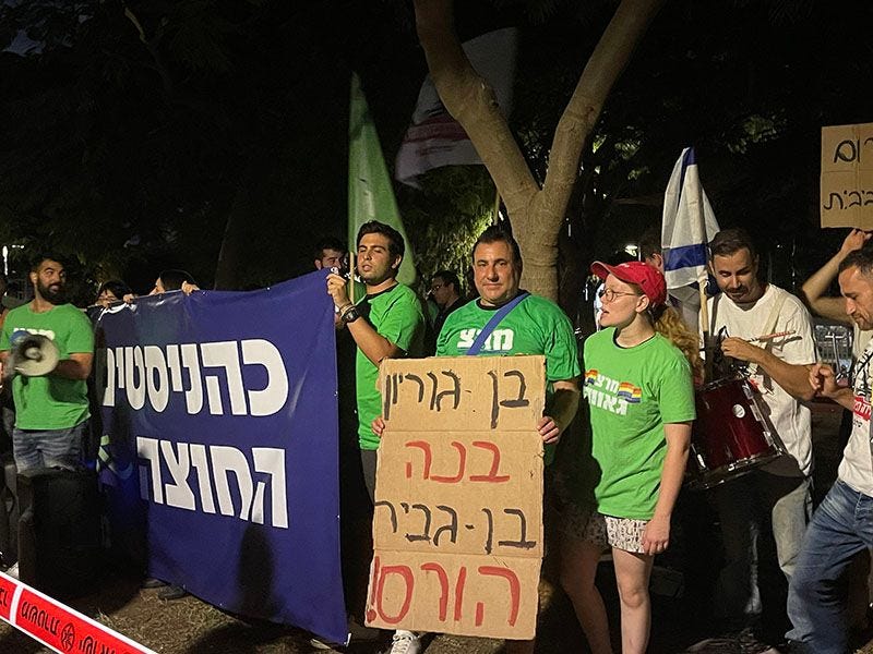 Left-wing protestors hold up signs reading "Kahanists out" and "Ben Gurion built, Ben Gvir destroys!" (Photo by Vivian Bercovici) Left-wing protestors hold up signs reading "Kahanists out" and "Ben Gurion built, Ben Gvir destroys!" (Photo by Vivian Bercovici)
