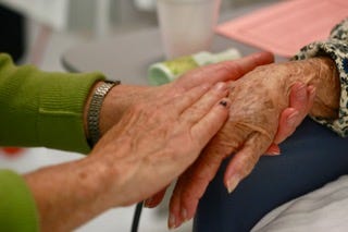 Hands of a young woman clasping an older woman's hands with love – photo credit: Sanford T. Rose
