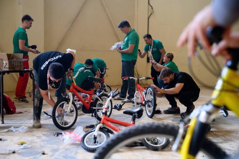 A group of people working on bicycles
Description automatically generated A group of people working on bicycles
Description automatically generated