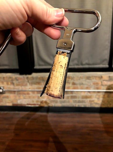 A gallery of cork closures: a natural cork branded 'Vila Voltaire' resting on a wine barrel table, a cork being pulled from a bottle with a waiter's corkscrew, and a cluster of Champagne corks and cages from various producers