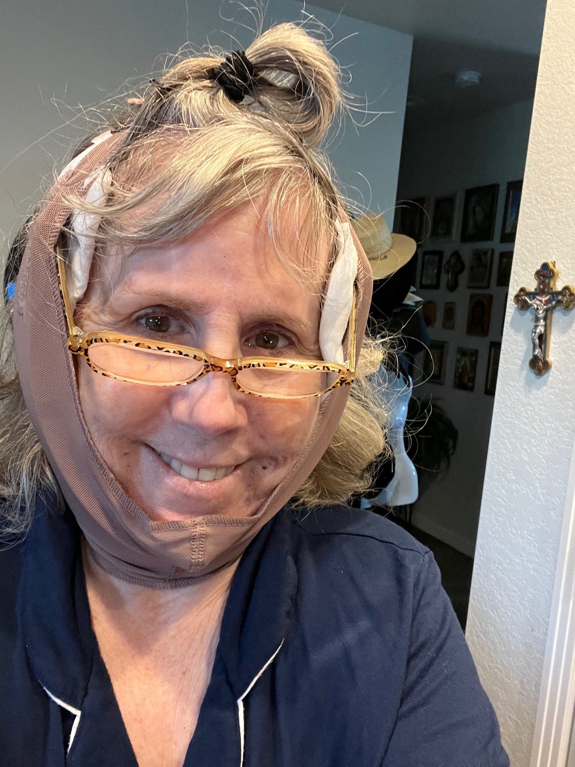 Author wearing reader glasses over her head bandage after having a face lift.