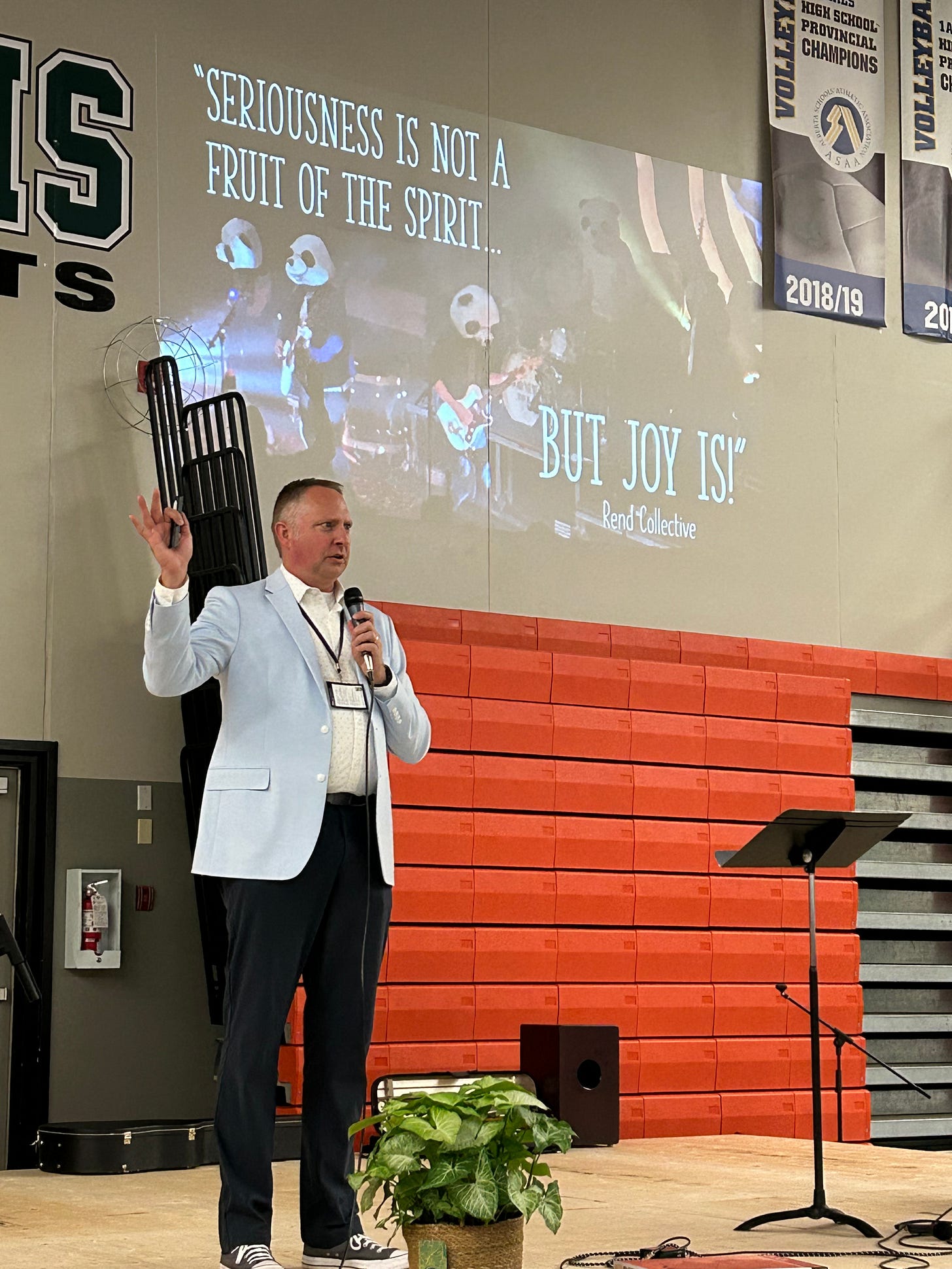 Dr. Dave on stage with the text "Seriousness is not a Fruit of the Spirit...but JOY is!" projected behind him.