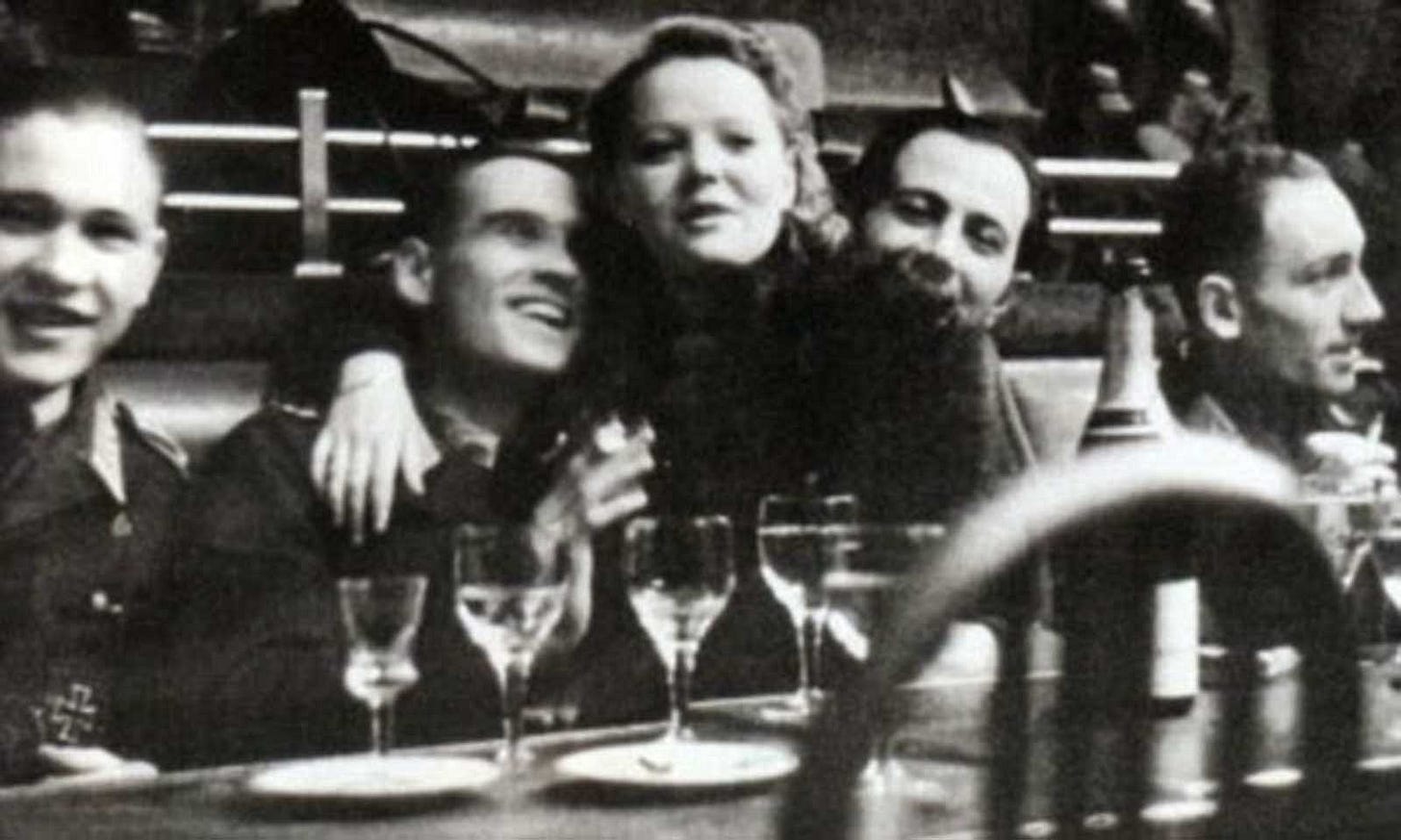 A festive atmosphere: A French woman openly socializing with SS members in a cabaret, challenging the notion that all women in occupied Europe were simply victims with no agency. A festive atmosphere: A French woman openly socializing with SS members in a cabaret, challenging the notion that all women in occupied Europe were simply victims with no agency.