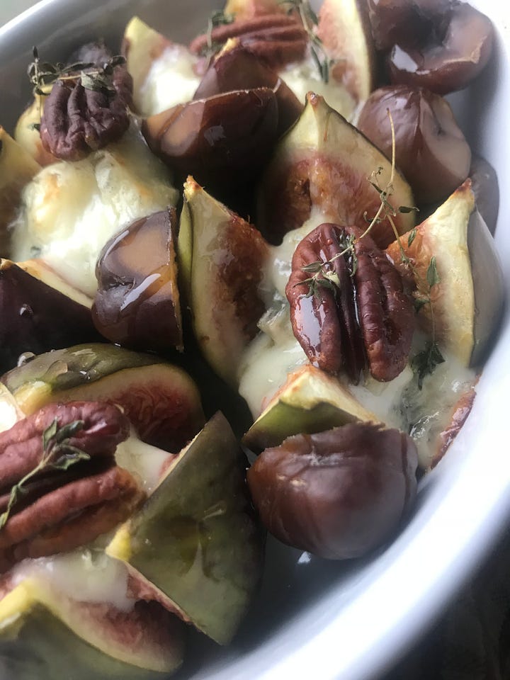 figs stuffed with blue cheese and pecans ready to be baked in a white dish Plus baked ones