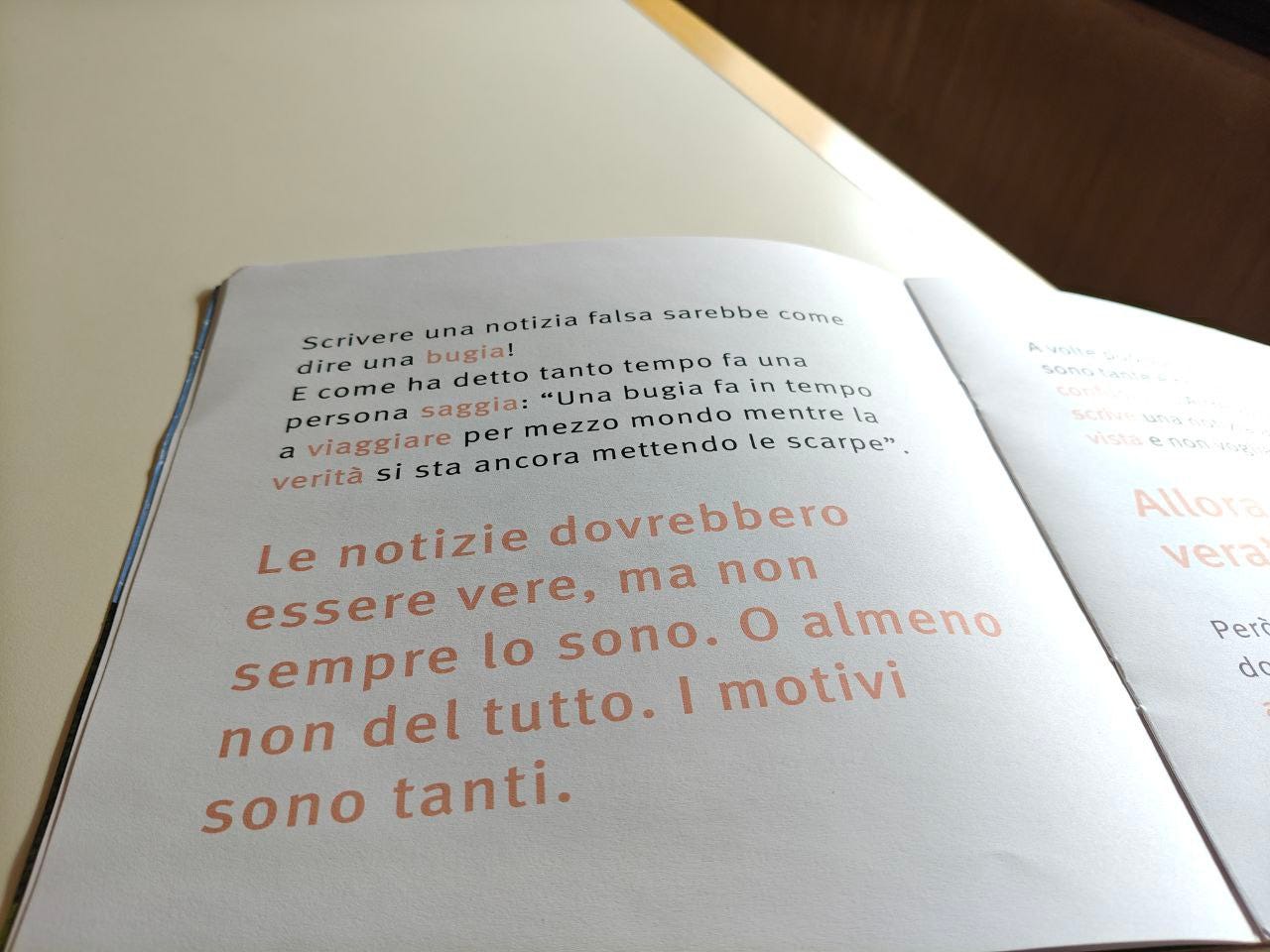 Una pagina della parola FALSO delle Scatoline di effequ, con questa scritta: "Le notizie dovrebbero essere vere, ma non sempre lo sono. O almeno non del tutto. I motivi sono tanti". La pagina è appoggiata su un tavolo di legno bianco sporco e nell'angolino in alto a destra si intravede un pezzetto di muro in ombra.